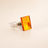 Rectangular Amber ring in silver on white cream background