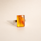 rectangular amber ring with orange gemstone on cream background