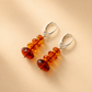 Amber bead drop earrings on a beige background