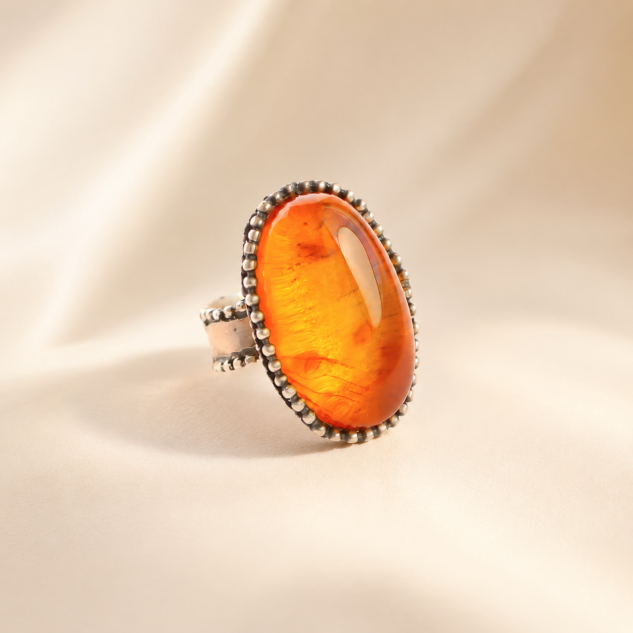 medieval statement Ring with a large orange stone on a beige background