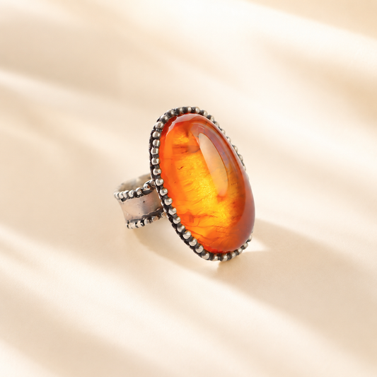 Medieval Statement Ring with amber stone on a beige background