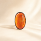 Medieval Statement Ring with a large amber stone on a beige background