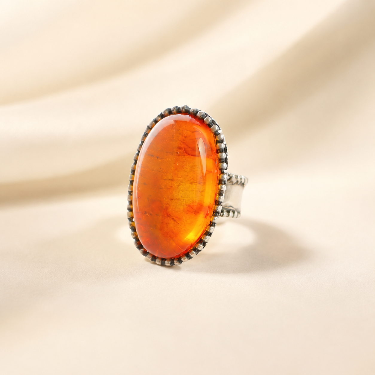 medieval statement Ring with a large amber stone on a beige background