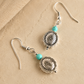 Silver western earrings with turquoise beads on a beige background