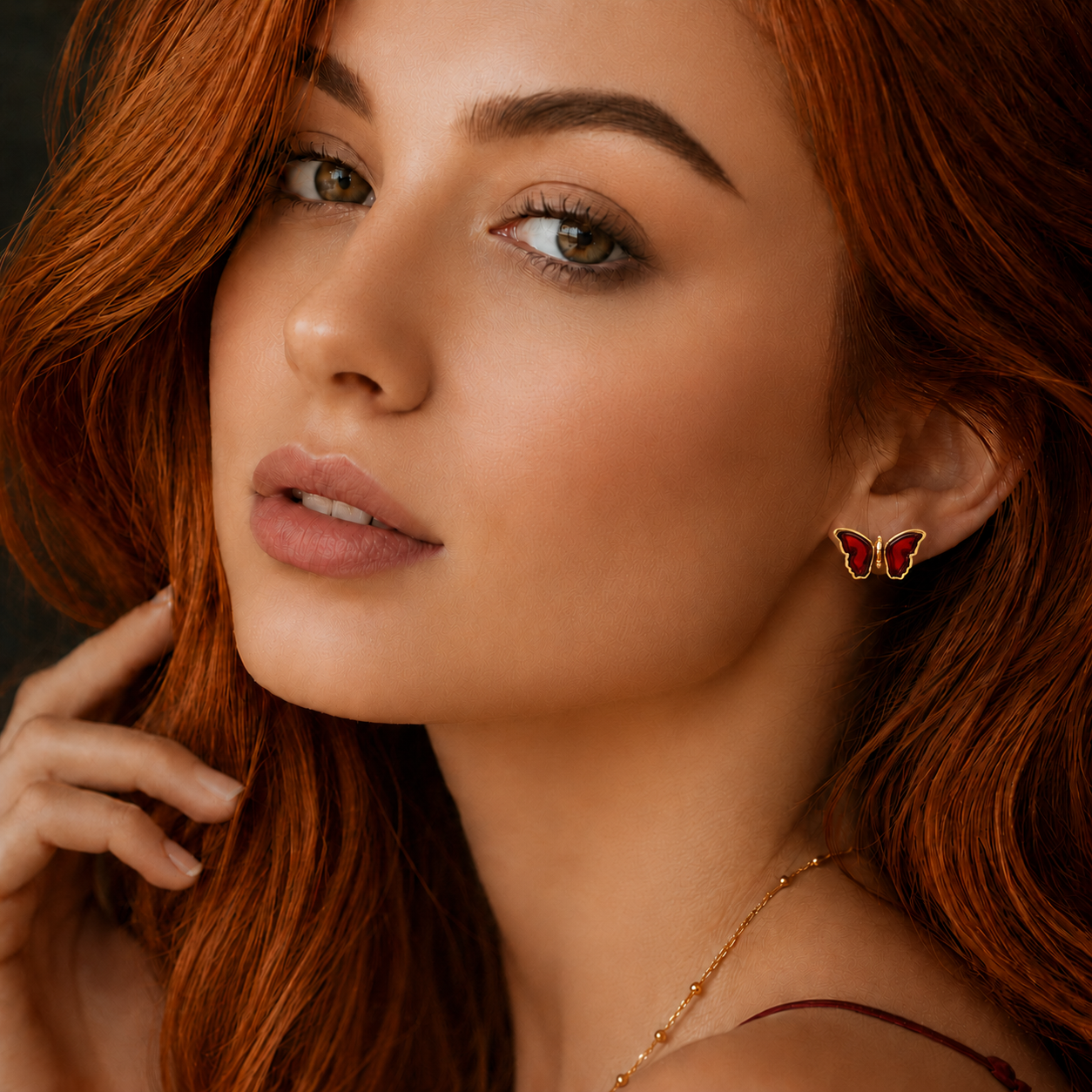 Close-up of a woman wearing butterfly gold stud earring with a blurred background