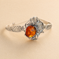 Silver amber bracelet with amber stone on a beige background