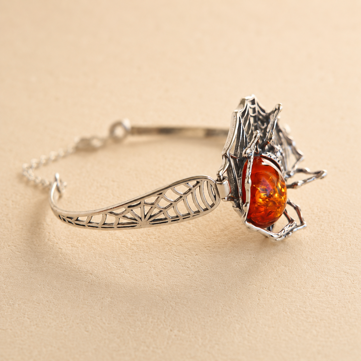Silver amber bracelet with an amber stone on a beige background