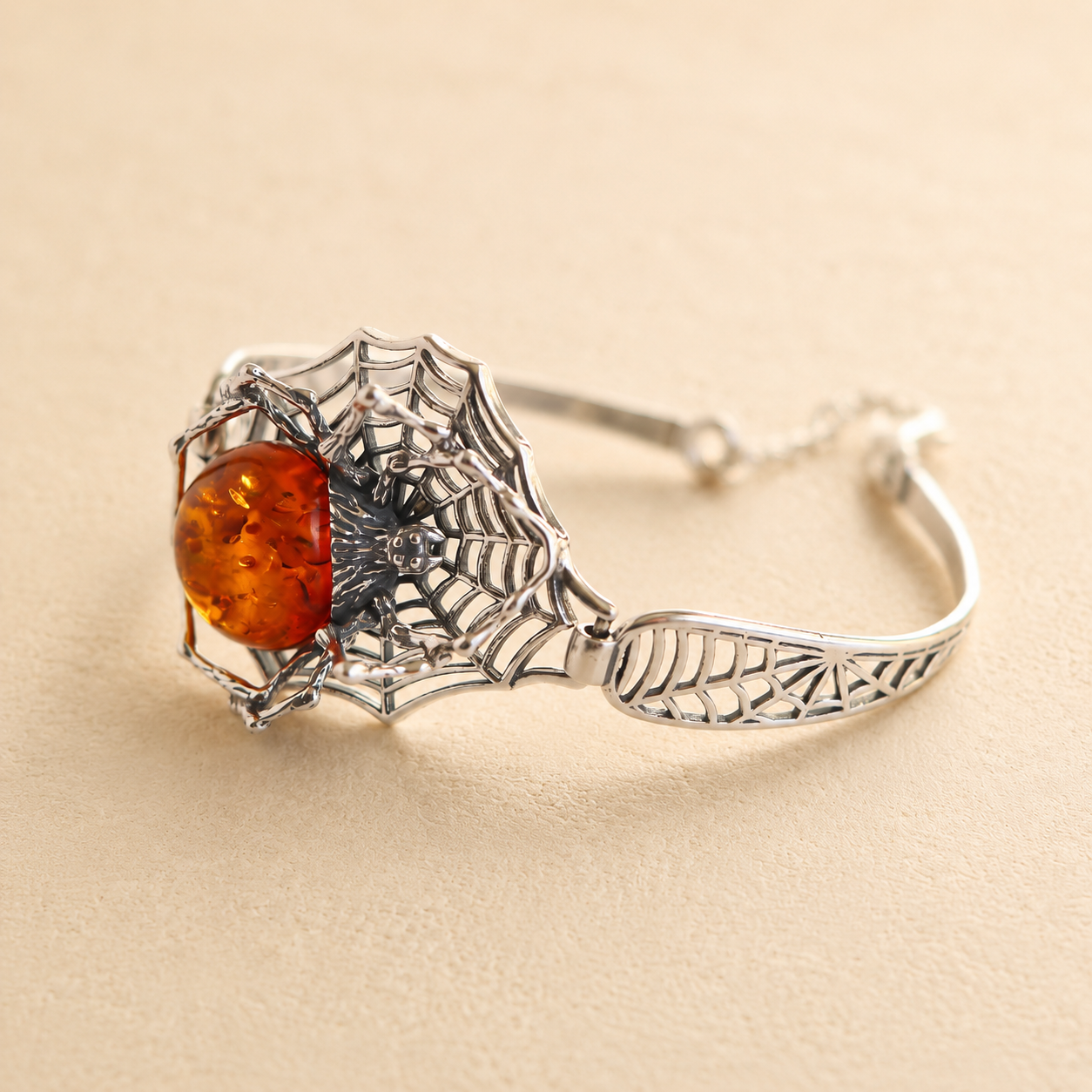 Silver amber bracelet with an amber stone on a beige background