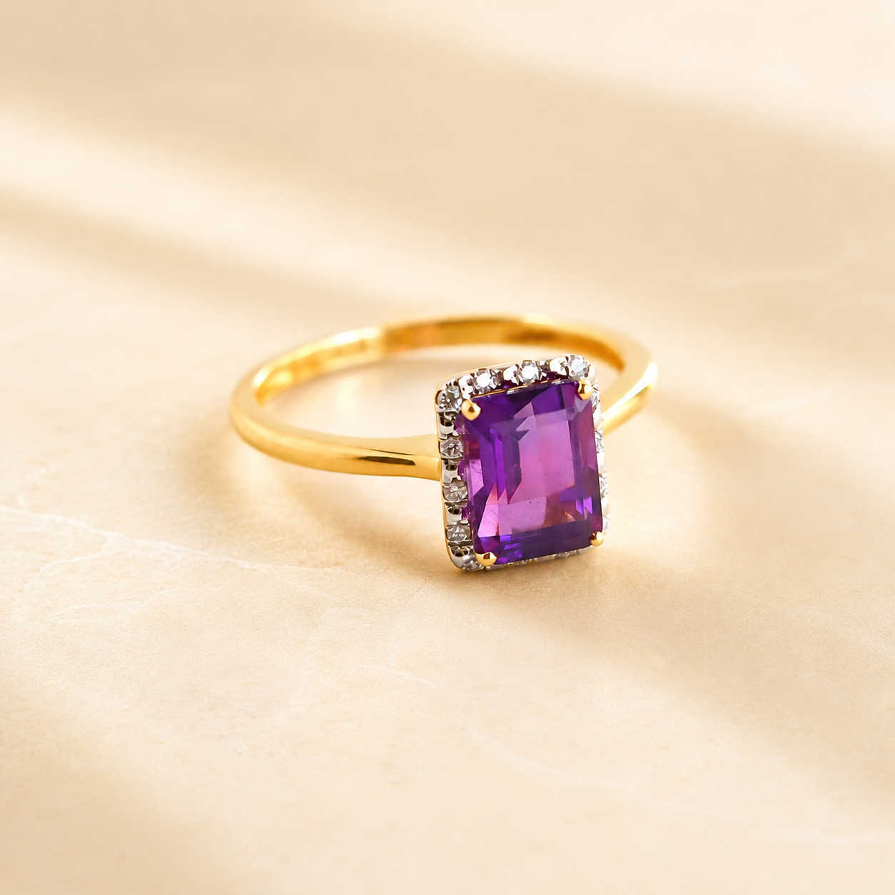 Gold Solitaire ring with a purple gemstone on a beige background