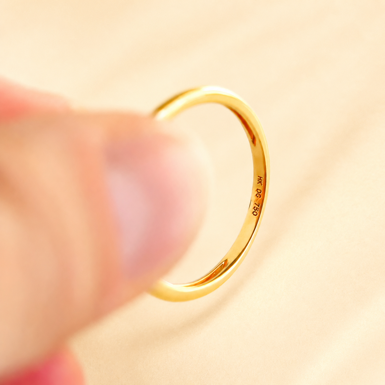 Gold Solitaire ring with 750 stamp on a soft focus background
