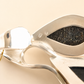 Close-up of a amber necklace with a textured stone inlay on a beige background