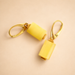 butterscotch amber earrings with gold hooks on a beige background
