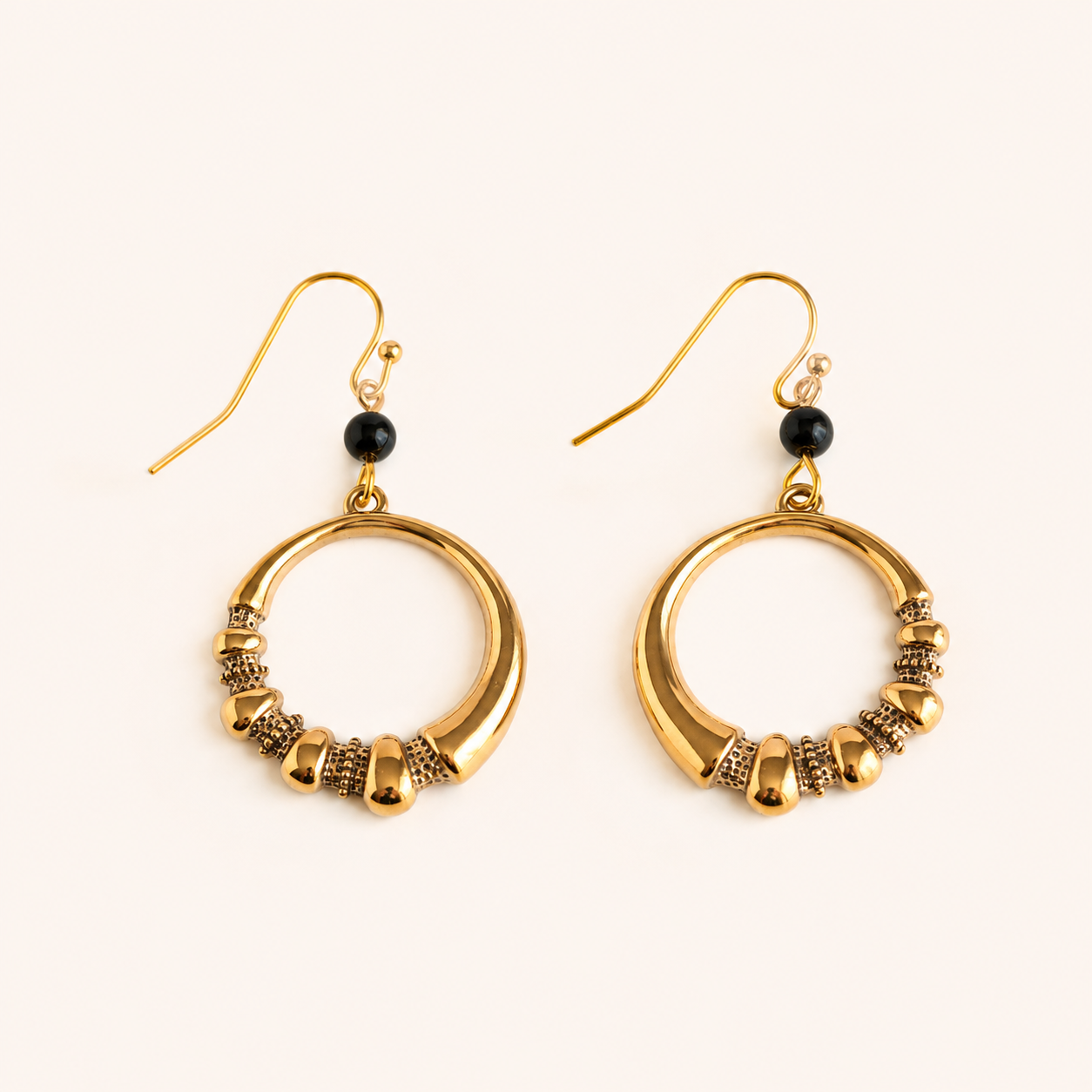 gold hoop earrings with black stone on white background