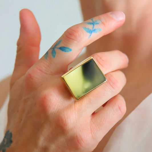 green amber ring in gold on hand