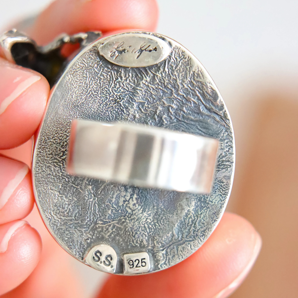 Silver statement ring  held in hand with 'S.S.' and '925' stamp visible