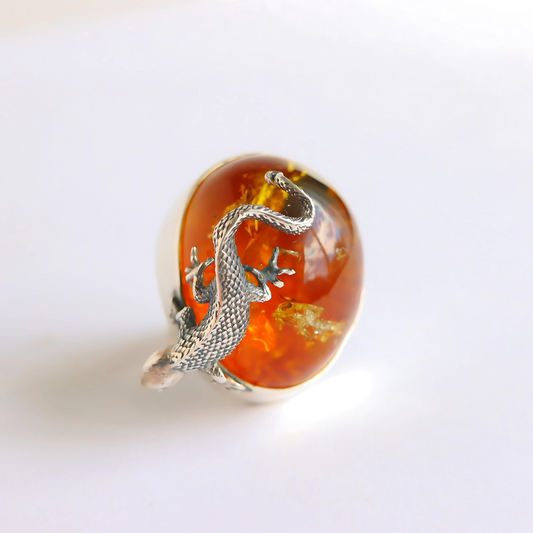 Statement ring with amber and silver dragon design on a white background