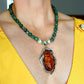 Cognac amber statement necklace with Canadian jade, green moss agate beads, and sterling silver pendant worn on model.