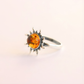 Silver amber ring with a sun design and amber stone on a light background