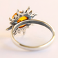 Silver amber ring with a sun design and amber stone on a light background