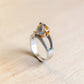 Back view of sterling silver frog ring showing textured frog detail, amber cabochon, and adjustable band.