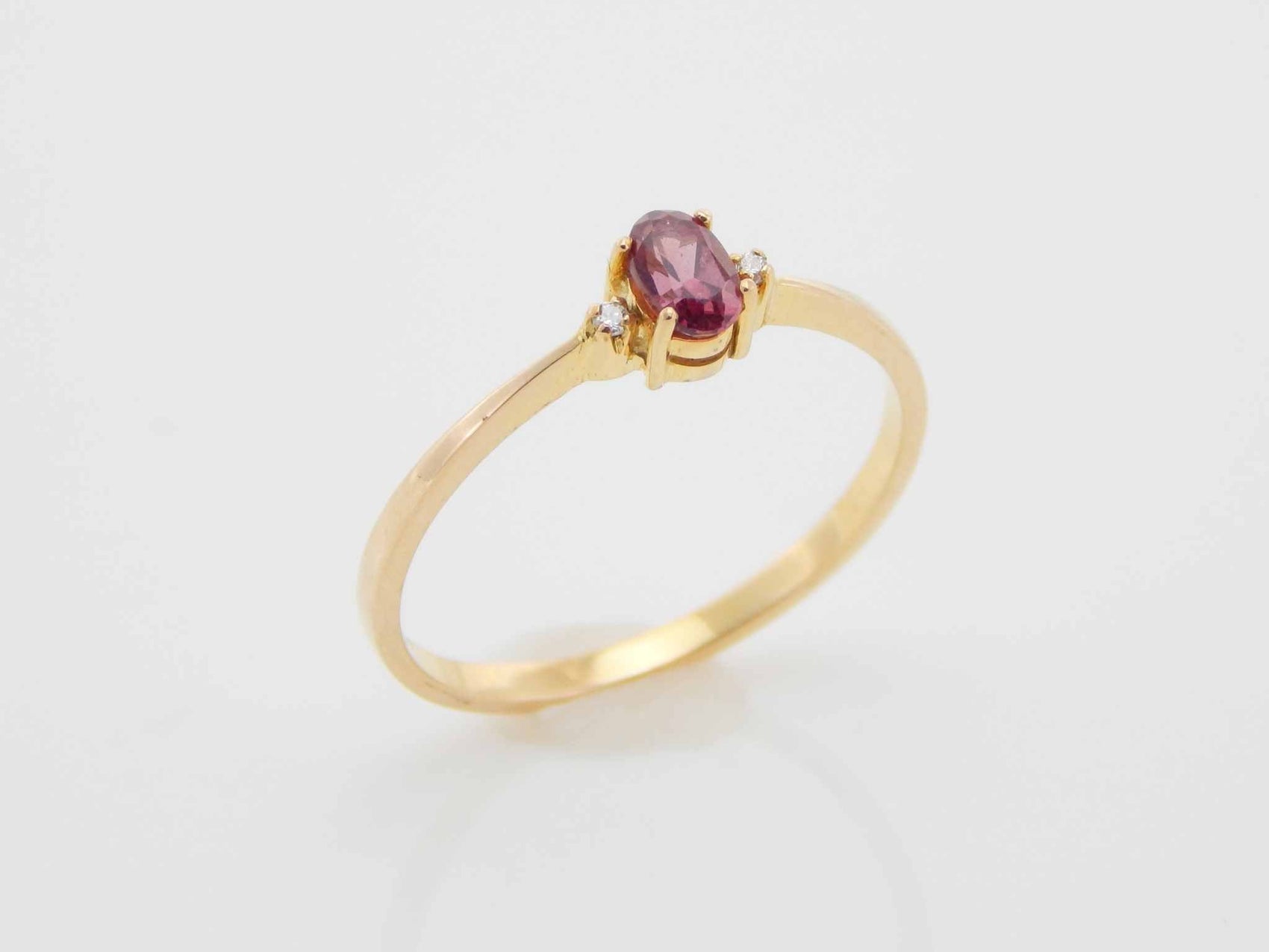 Genuine 14k Gold Garnet ring with diamonds in prong setting.