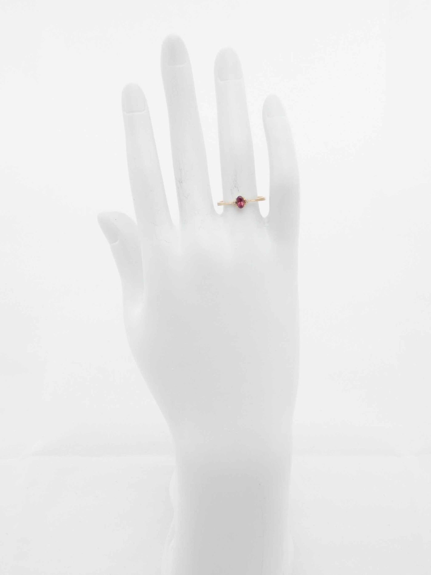 Genuine 14k gold garnet and diamond ring on mannequin hand.
