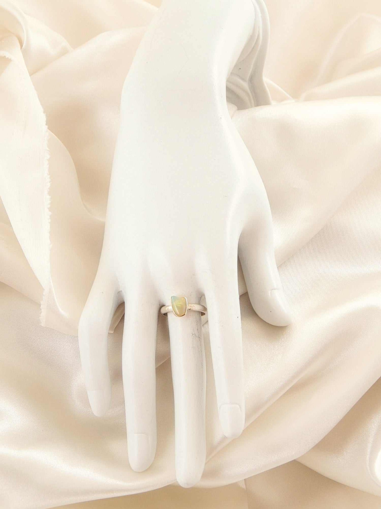 Genuine Ethiopian opal ring in 925 sterling silver with vivid colors on display mannequin.