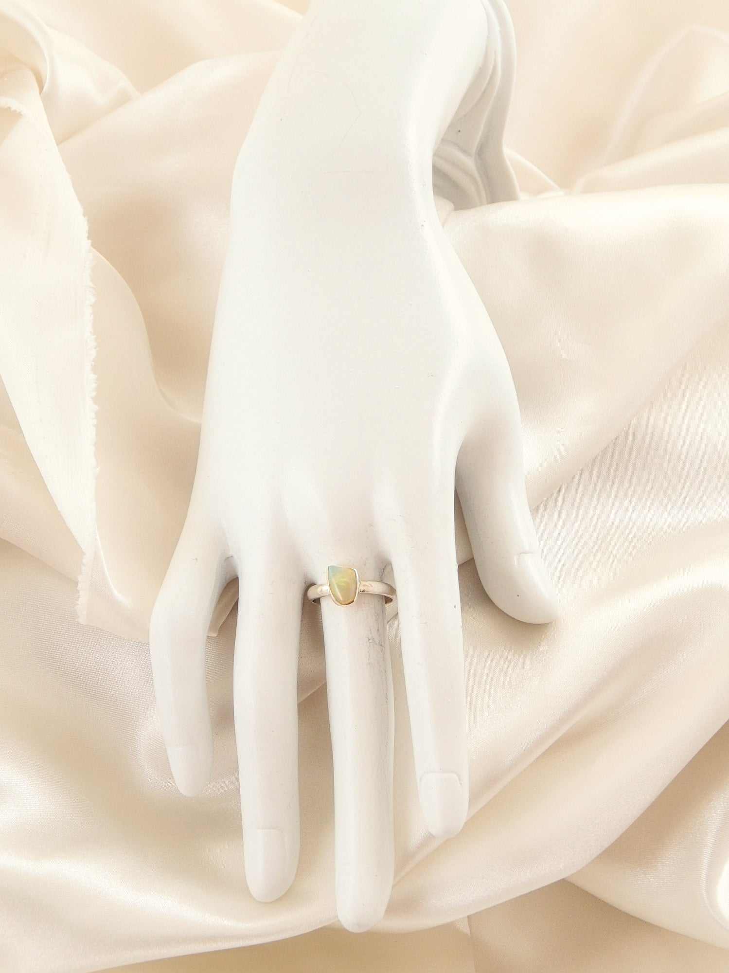 Genuine Ethiopian opal ring in 925 sterling silver with vivid colors on display mannequin.