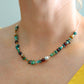 Turquoise beaded necklace with cherry amber and sterling silver chain worn on neck