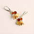 Bee and honeycomb pattern amber earrings on a beige background