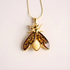 Gold insect-shaped amber necklace t on a light background