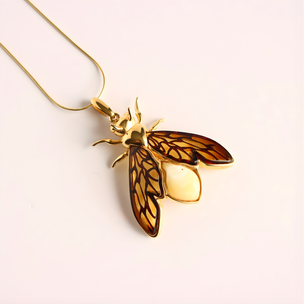 Gold and tortoiseshell bumble bee amber necklace on a light background