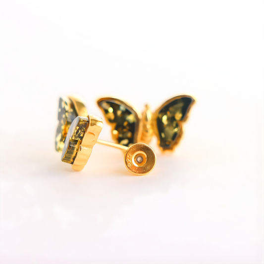 Gold butterfly amber earrings on a white background