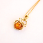 Gold spider amber necklace with stone on a white background