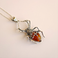 Spider-shaped pendant  amber necklace on a beige background