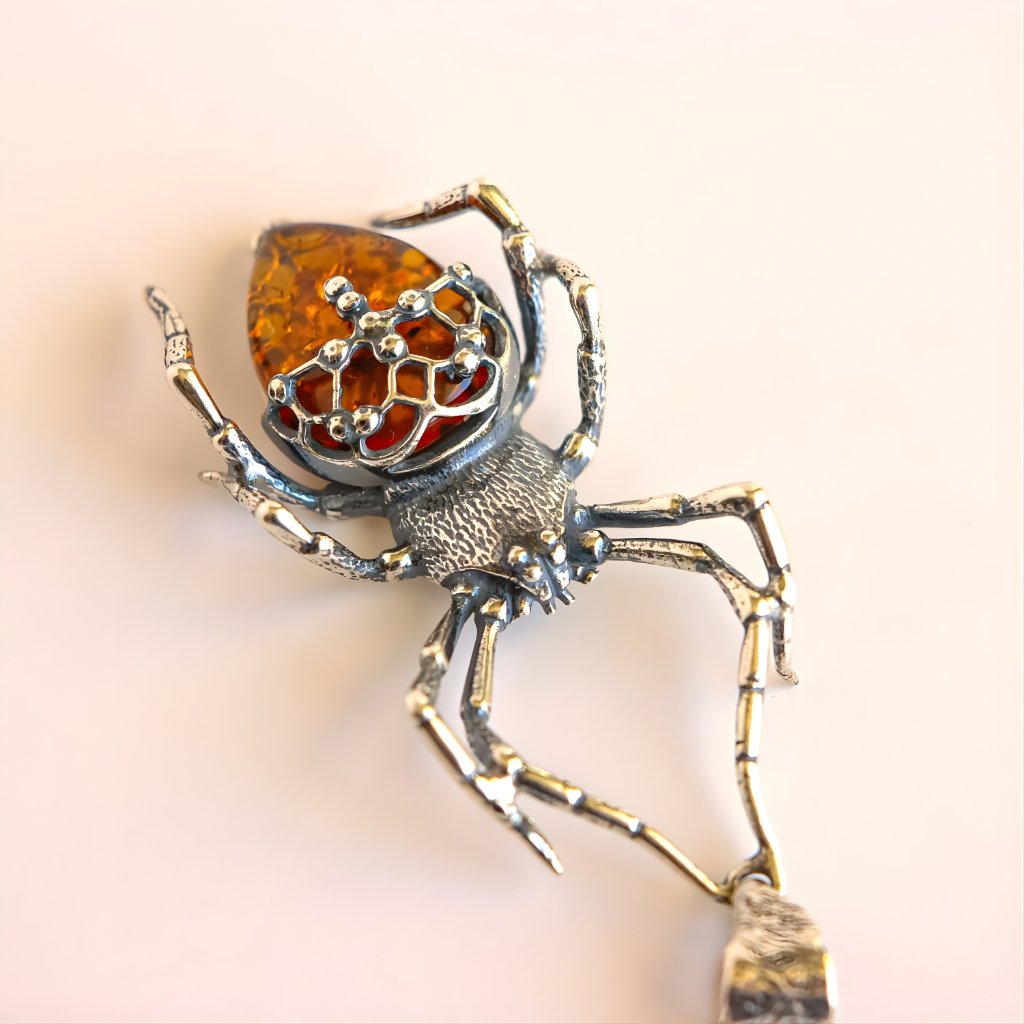 Silver spider amber necklace with amber inset on a light background