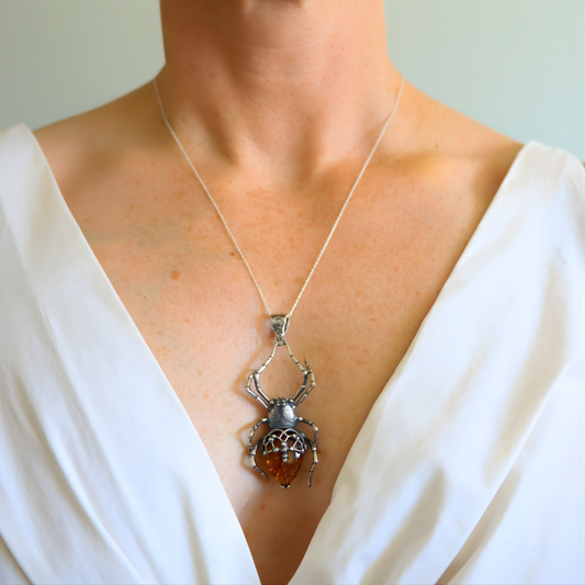 Person wearing a amber  necklace with a spider pendant
