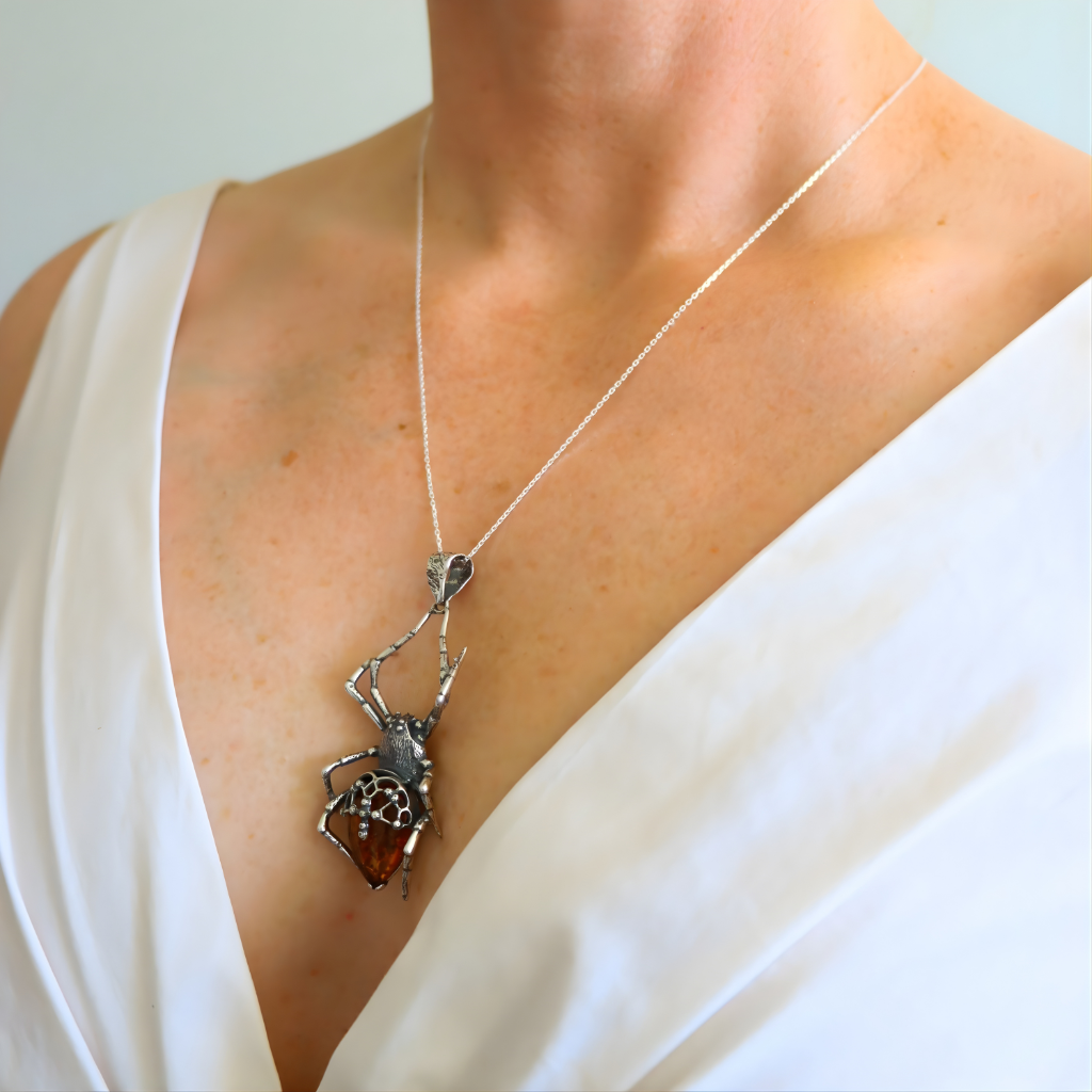 Spider pendant amber necklace on a person wearing a white top