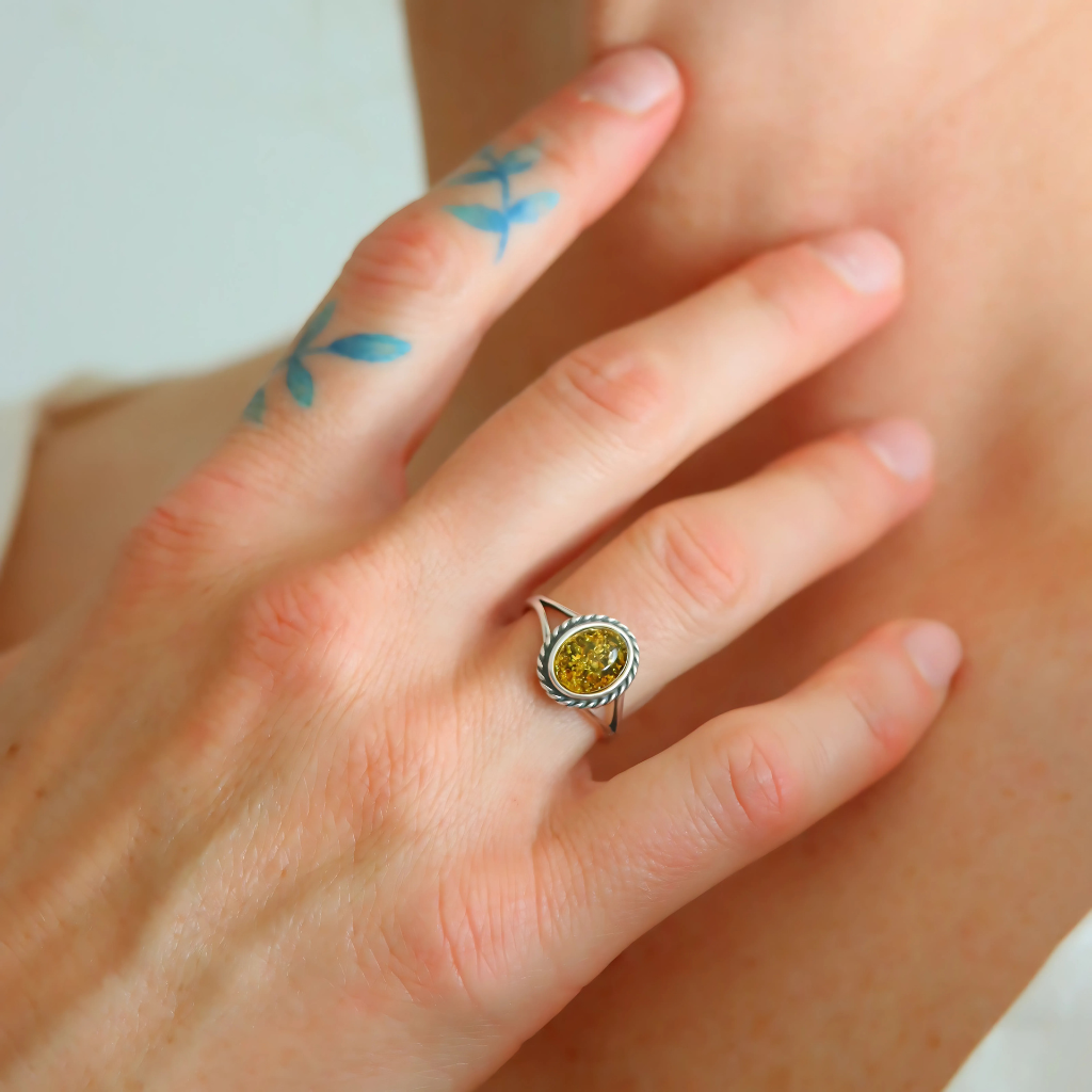 green oval cut ring on hand