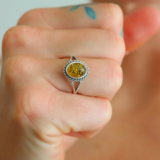 green oval cut ring top view on hand