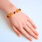 Handmade Baltic amber bracelet with butterscotch, cherry, and cognac stones on gold-colored chain.