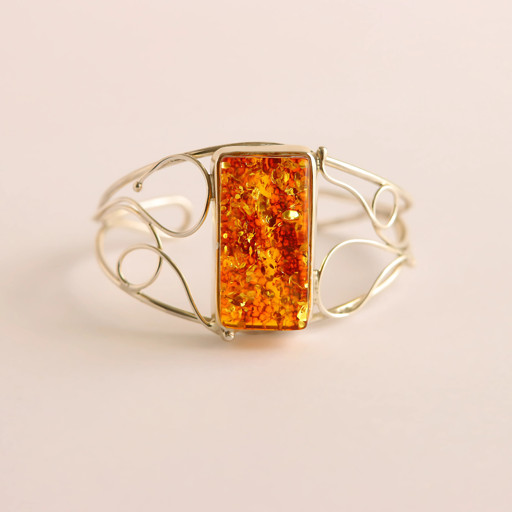 cuff bracelet with a rectangular amber stone on a beige background