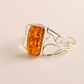 cuff bracelet with a large amber stone on a light beige background