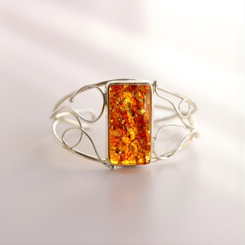 Silver cuff bracelet with a rectangular amber stone on a light background