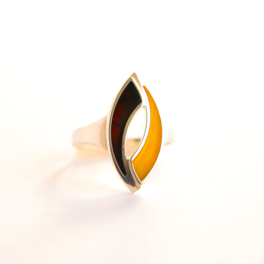 Gold and black amber ring with a unique design on a white background