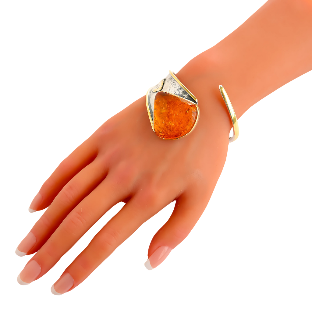 Handmade Baltic cognac amber cuff bracelet in 925 sterling silver with 14k gold plating on wrist.