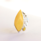 butterscotch amber Ring with yellow teardrop-shaped stone and silver band on a light background