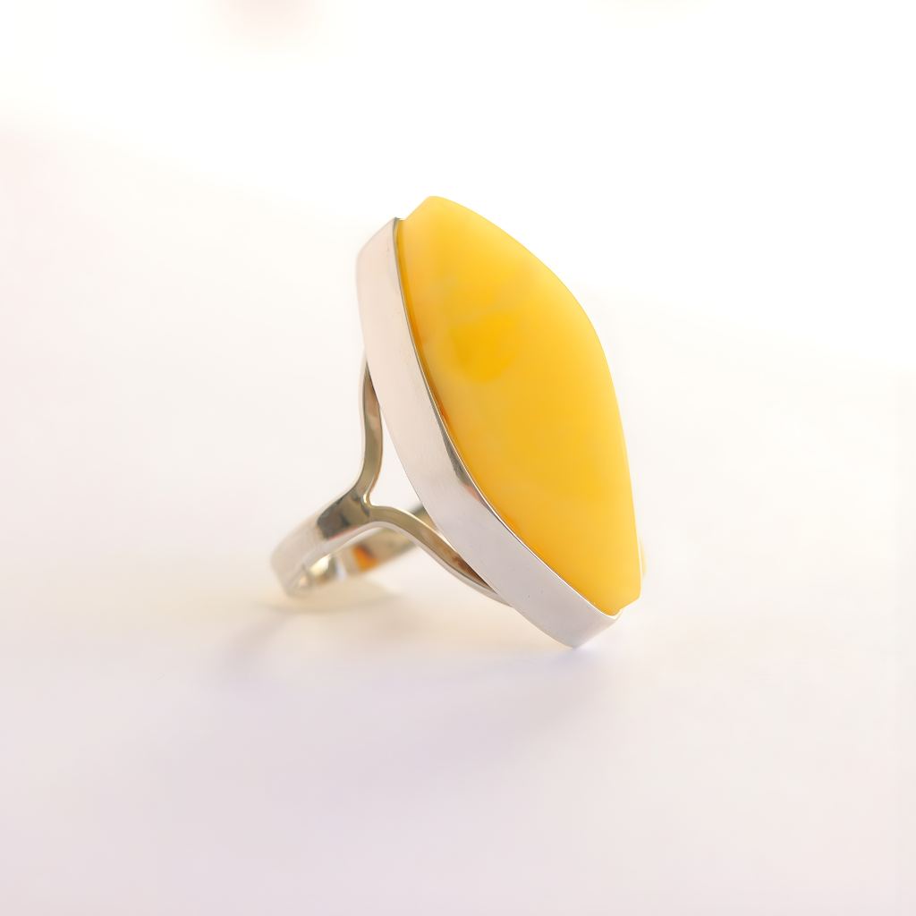 butterscotch amber Ring with a yellow teardrop-shaped stone on a white background