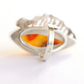 Silver butterscotch amber ring with a red and yellow stone on a white background