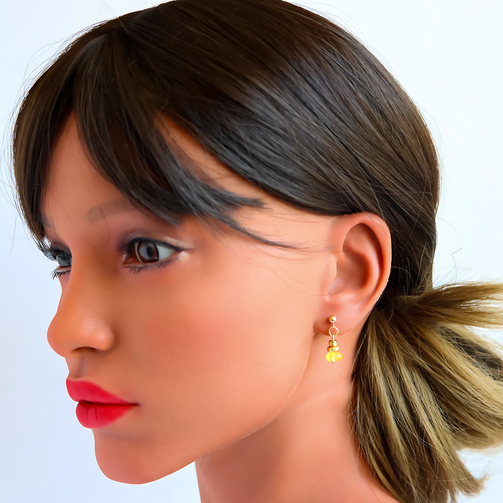 Handmade gold Baltic lemon amber earrings displayed on mannequin.
